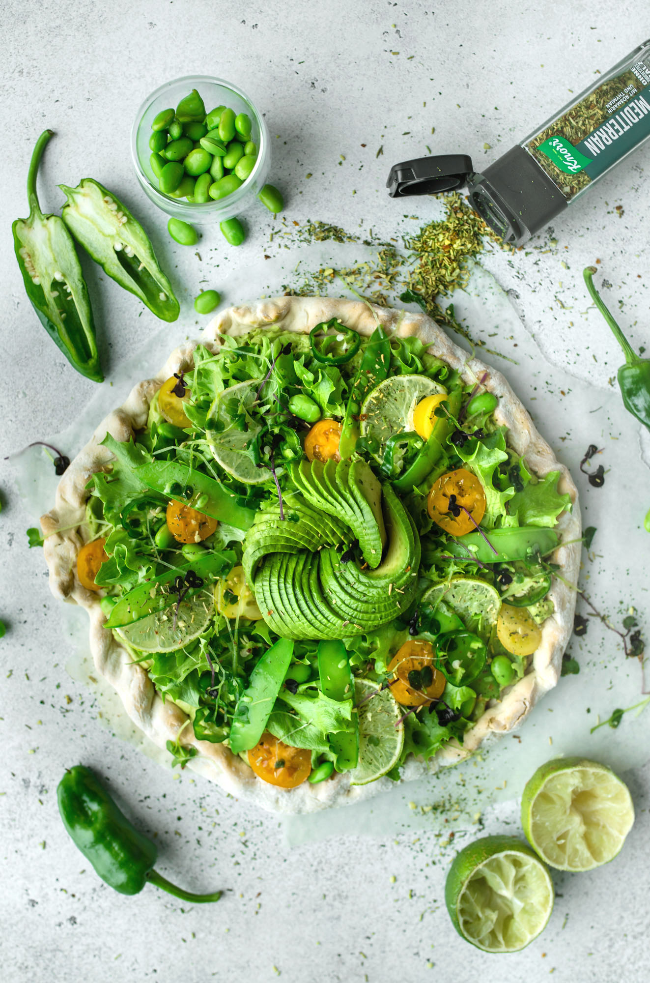 Frühlingshafte vegane Pizza mit Guacamole Topping